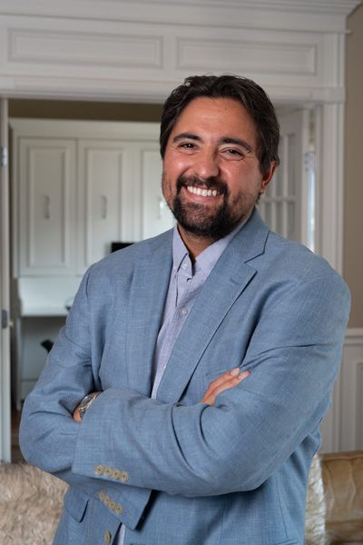 Portrait of Pete Gonzales in a blazer, arms folded.