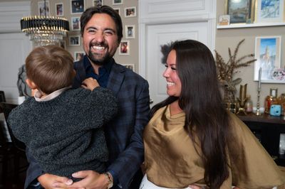 Pete Gonzales at home with his family, holding a small child who is turned away from the camera.